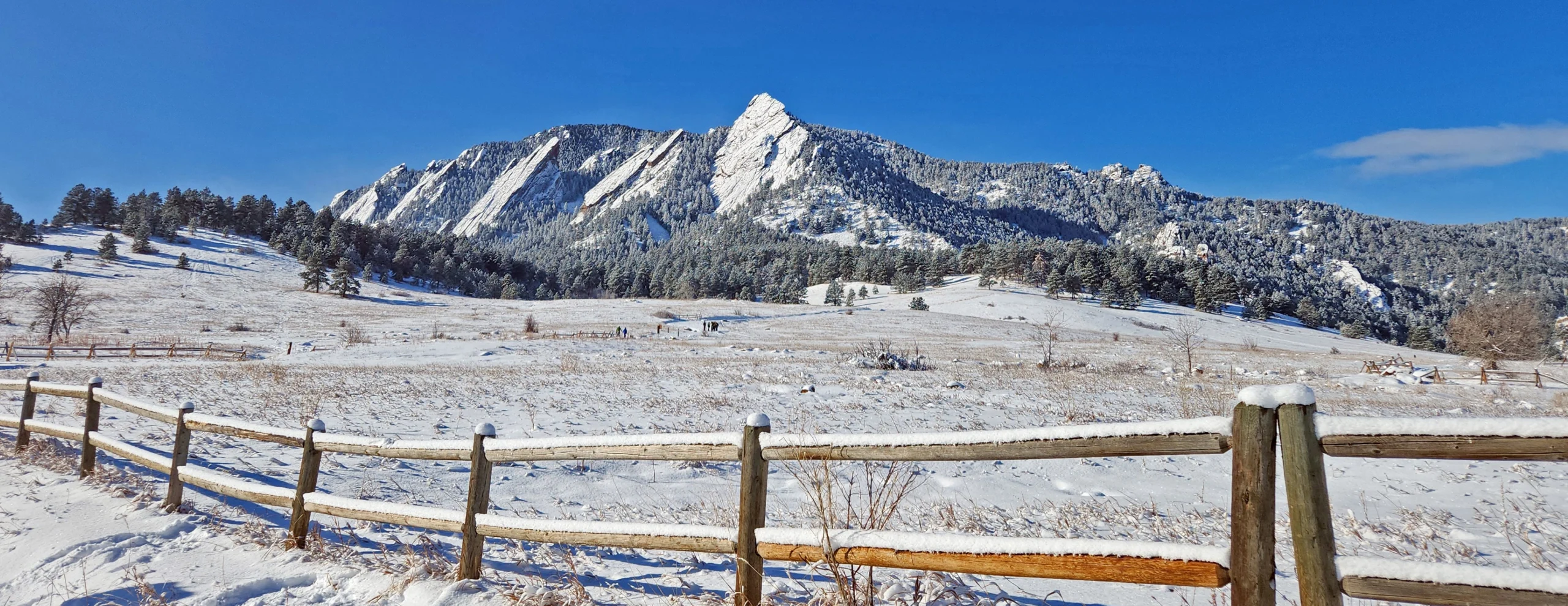 Dramatically tilted sedimentary rocks covered in fresh snow. The Flatirons, Chautauqua Park, Boulder, CO (December, 2026 CGS Geology Calendar). Photo credit: Orna Buch-Leviatan (CGS)