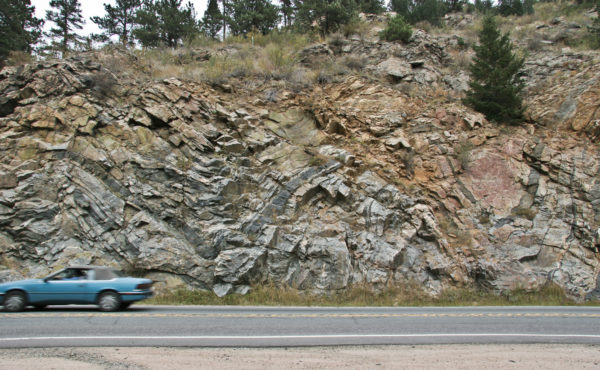 Anticline and synclines in Precambrian metamorphic rocks in Clear Creek Canyon near Blackhawk, Colorado. Within these large folds are many small, tight folds that formed during an earlier period of folding then later were refolded. Photo credit: Vince Matthews for the CGS.