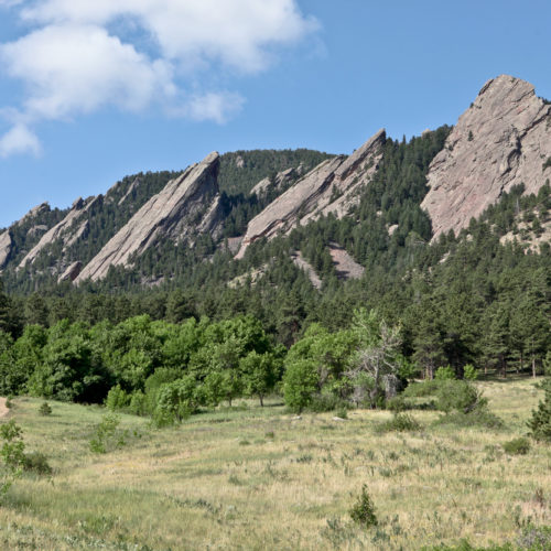 The Flatirons overlooking Boulder, Colorado are comprised of once flat-lying Permian Fountain Formation sedimentary rock that were tilted to 50 degrees by the orogenic uplift of the Rocky Mountains. Photo credit: Vince Matthews for the CGS.