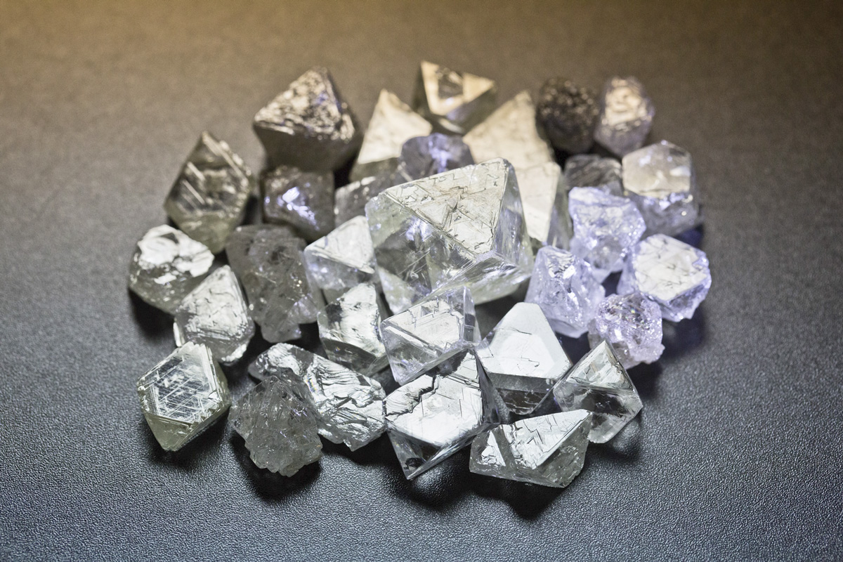 Diamonds in the rough, note the regular octahedral forms and trigons (of positive and negative relief) formed by natural chemical etching. Photo credit: Wikimedia.