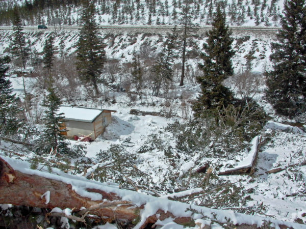 One intact and one destroyed structure at the water treatment plant, with I-70 in the background, Silver Plume, Colorado. Photo credit: Colorado Geological Survey.