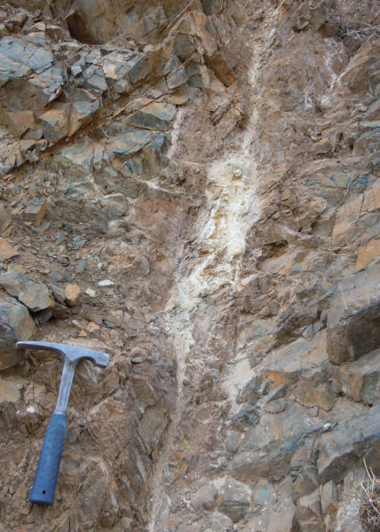 This carbonate fault vein bearing pitchblende (an olive-green-colored mineral containing uranium oxides) near the Schwartzwalder Mine is similar to the faults that run under Ralston Creek, Colorado. The largest known hydrothermal vein type deposit of uranium in the United States occurs at the Schwartzwalder Mine, Colorado. Photo credit: Jonathan Caine, USGS.
