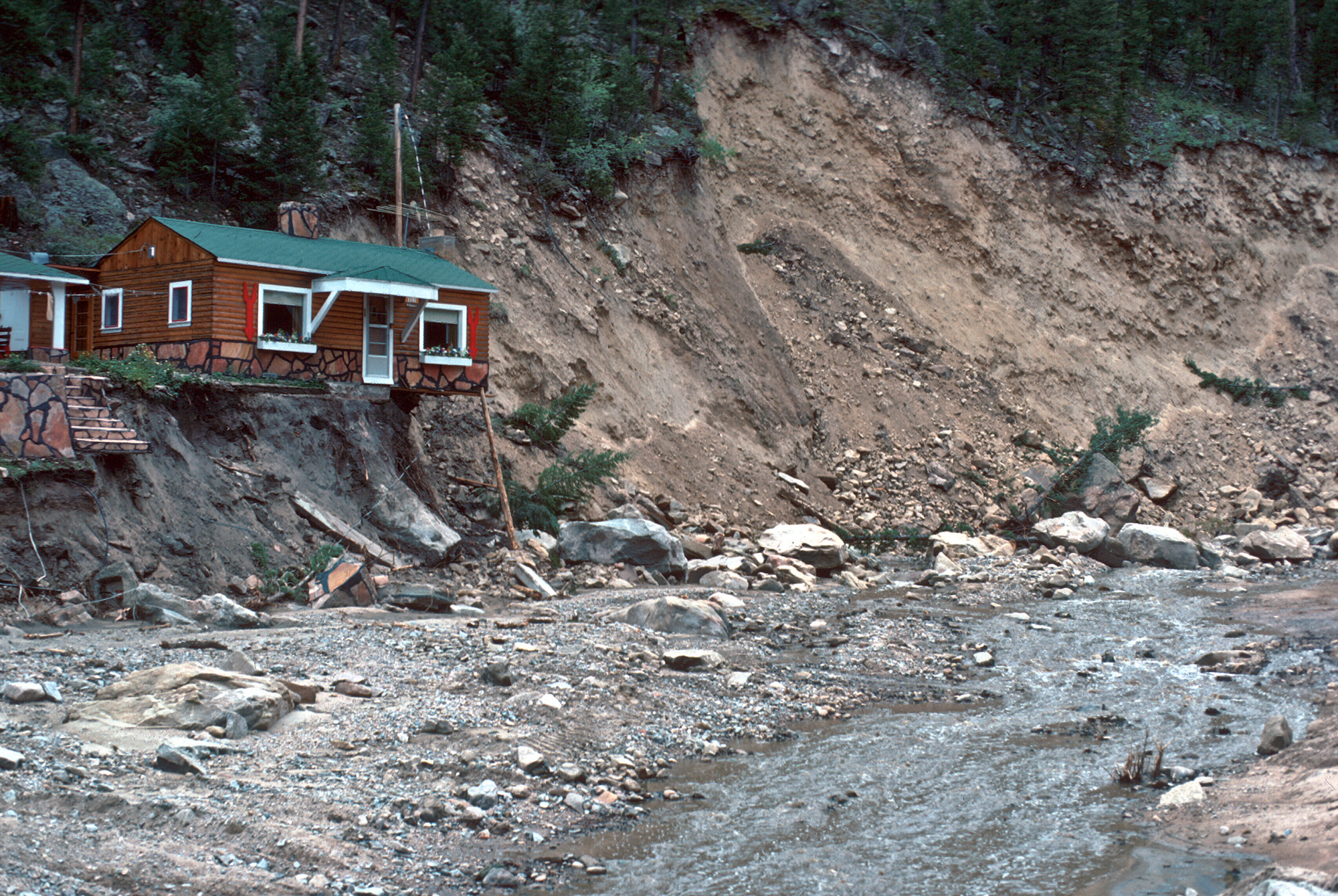 House precariously undercut by lateral scour on the Big Thompson River a quarter of a mile below Glen Comfort, Larimer County, August 1976. Photo credit: Ralph Shroba.