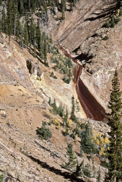 Actively forming ferrosinter deposit (dark brown area) in Bedrock Creek in the La Plata Mountains of southwest Colorado. The area is underlain by mineralized igneous rocks that contain abundant pyrite and chalcopyrite. Photo credit: Colorado Geological Survey.
