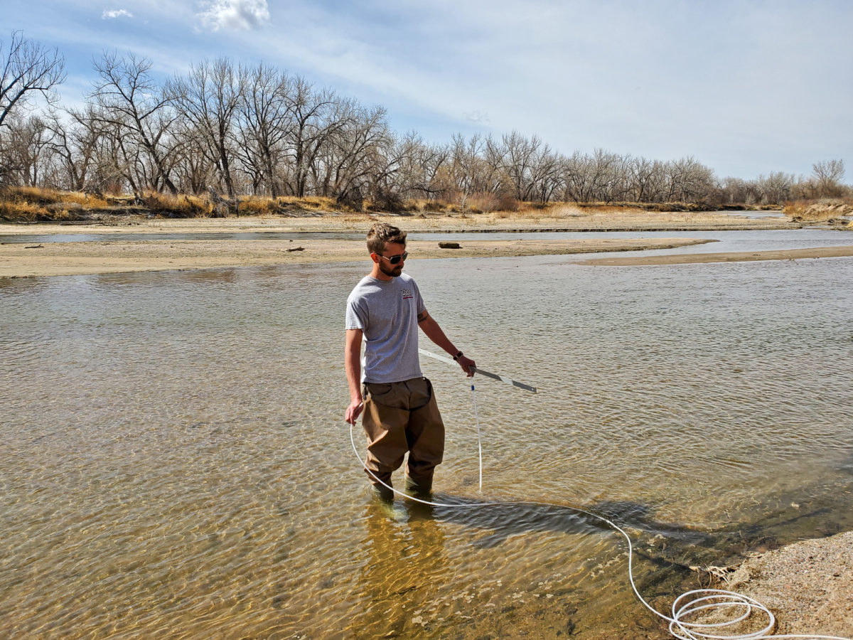 Aaron Lynch of Neirbo Hydrogeology sampling water in April 2022 during an ongoing CGS salinity study of the South Platte River. Photo credit: Lesley Sebol for the CGS.